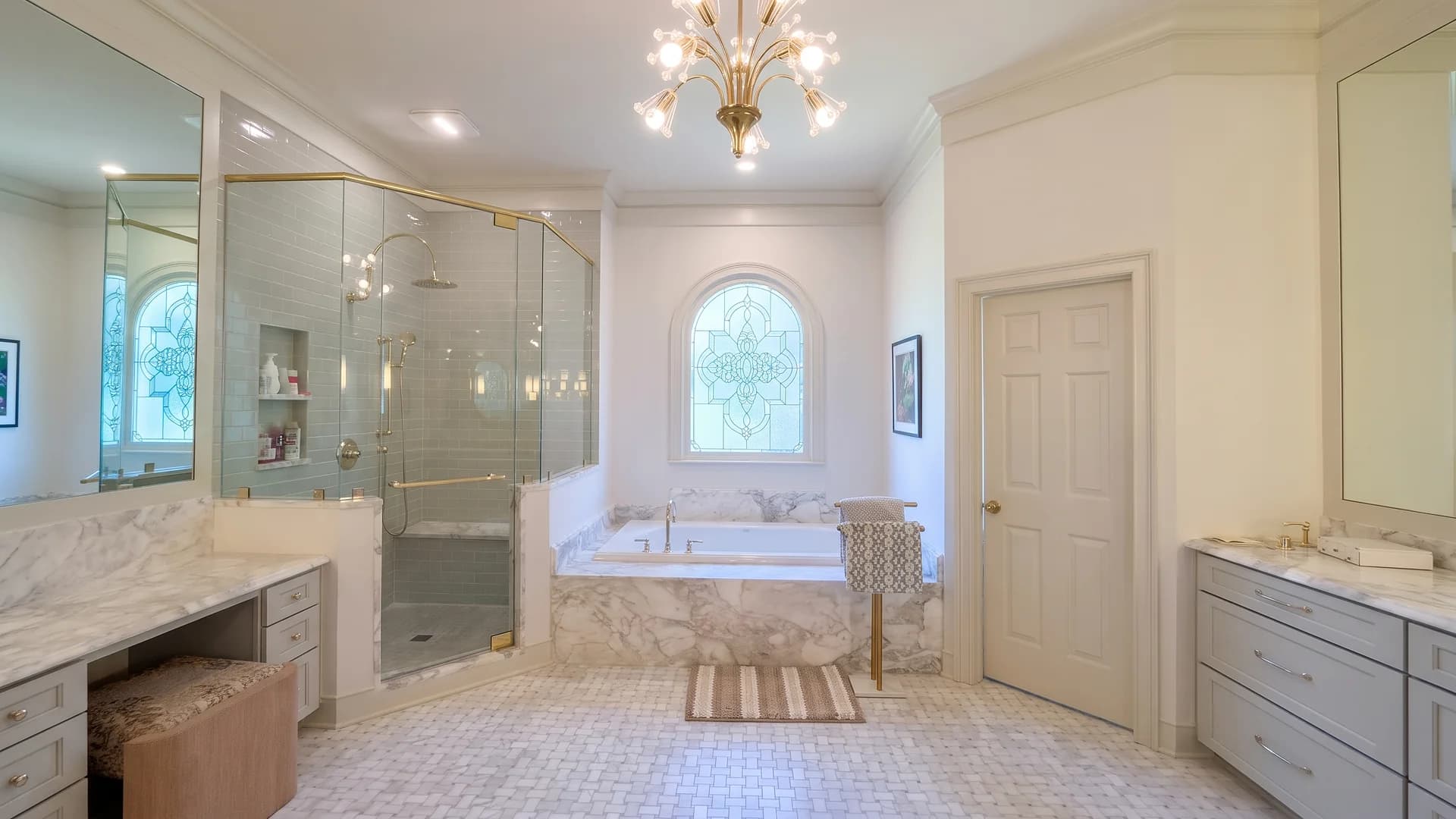 Finished master bathroom with a glass shower, marble-look tub surround, and basketweave mosaic floor