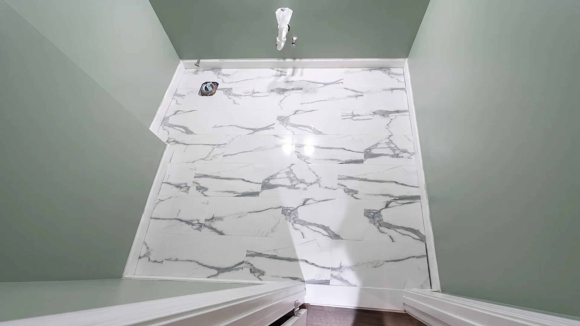 White marble-look tile floor installed in a bathroom